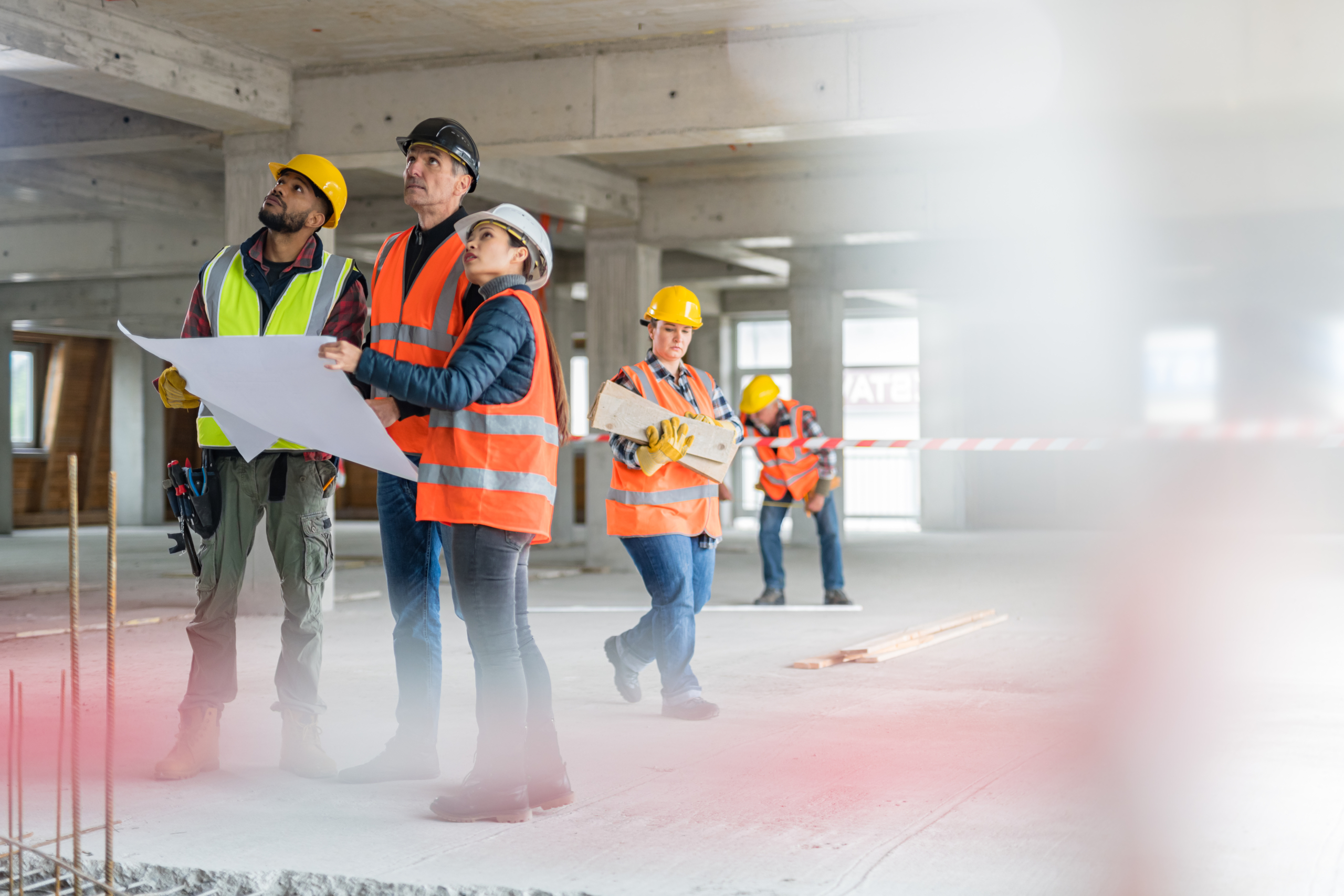 Architects discussing blueprint with construction worker